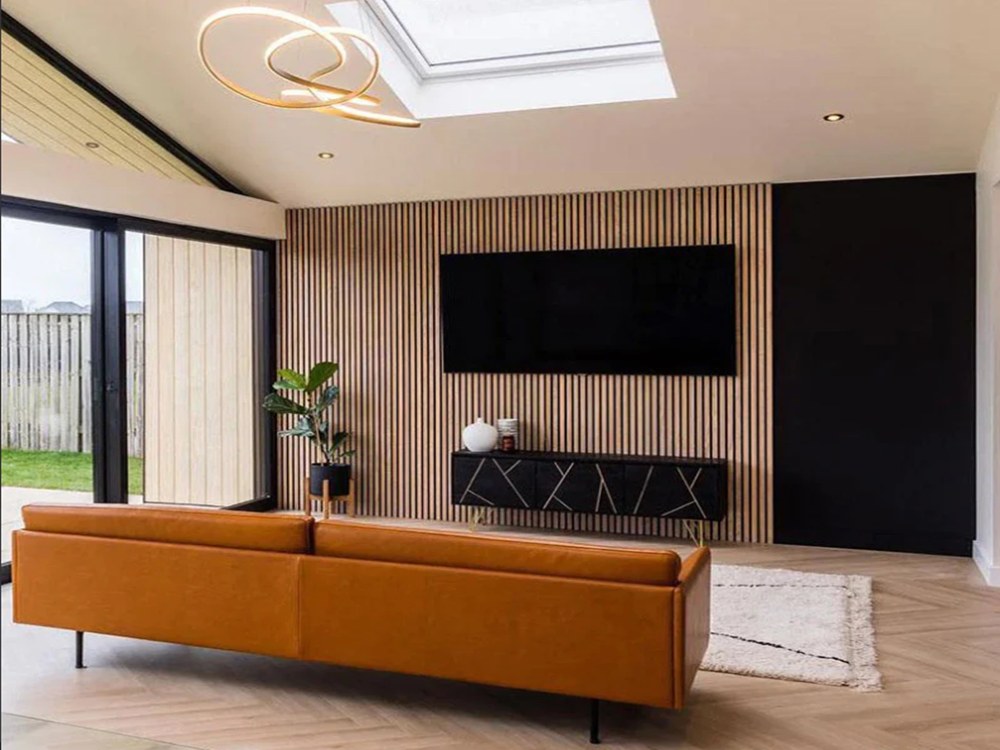 Fluted wall panels in a bright living room with timber tones and an orange sofa